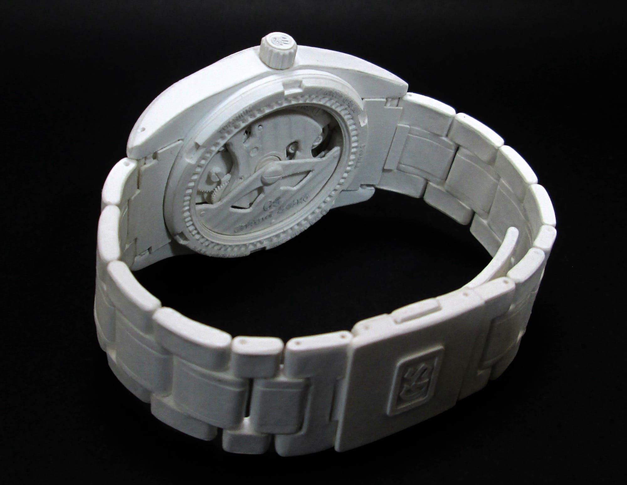 a hyperrealistic, scale sculpture of a watch made from white paper