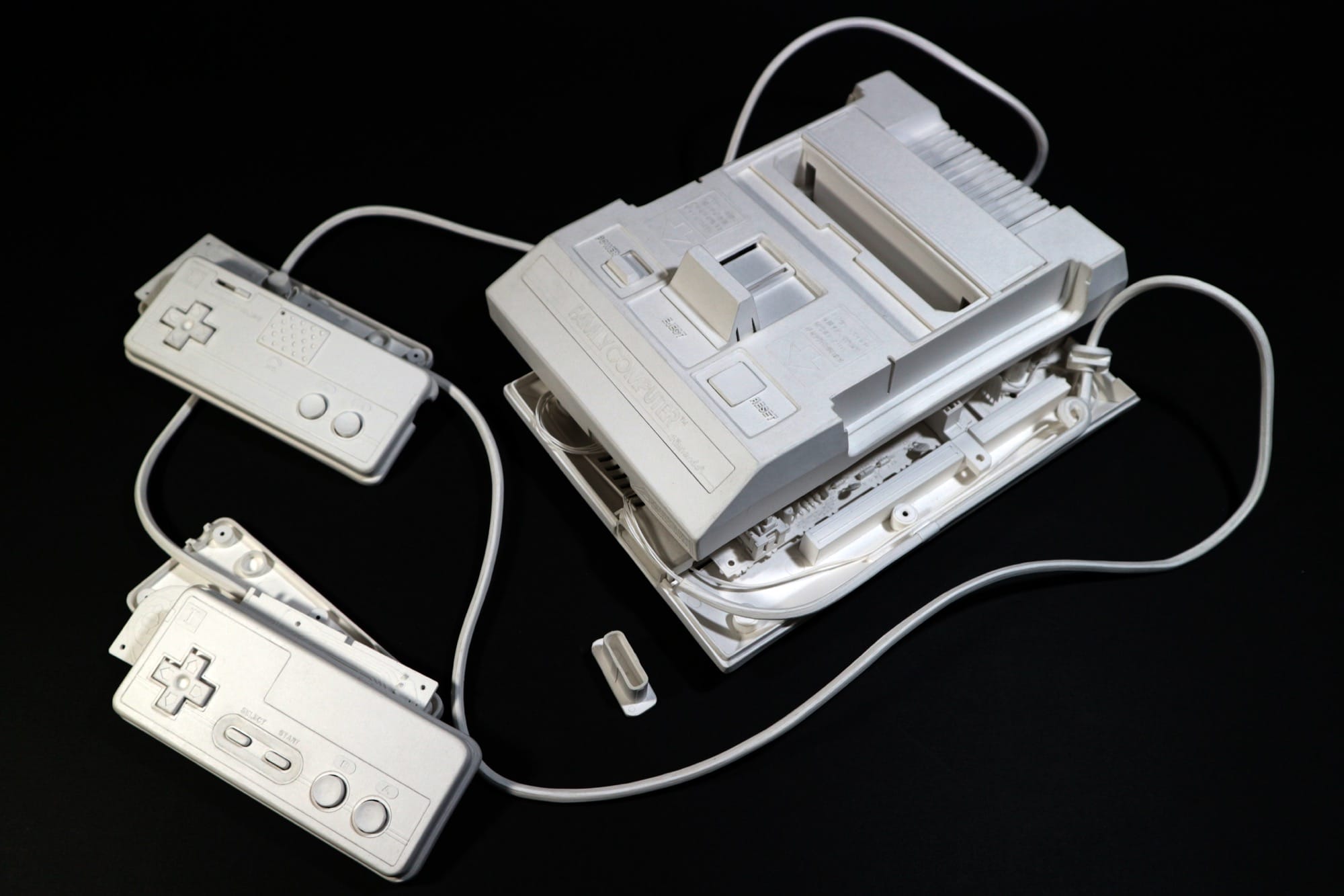 a hyperrealistic, scale sculpture of a video game console made from white paper