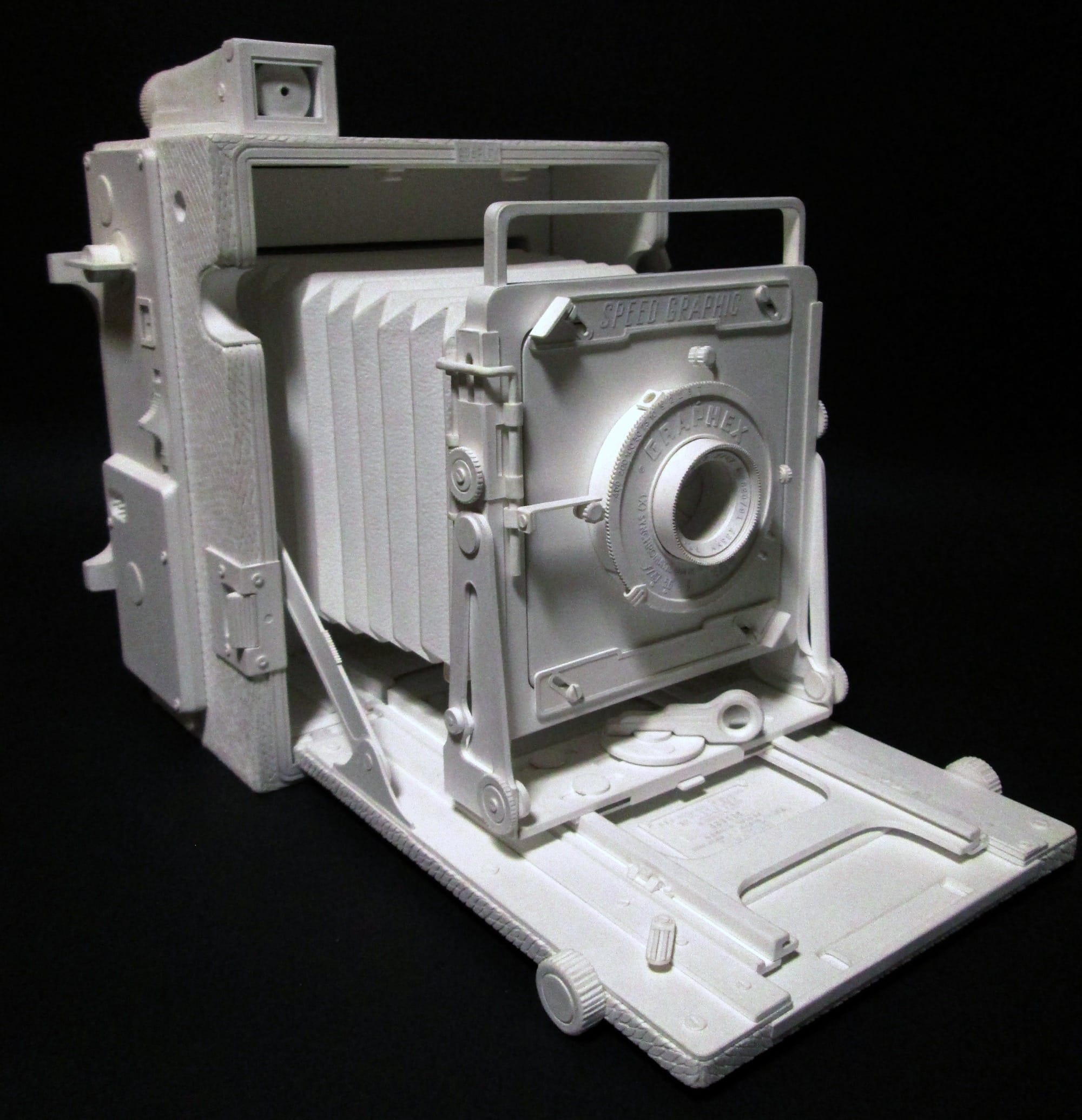 a hyperrealistic, scale sculpture of a large-format camera made from white paper