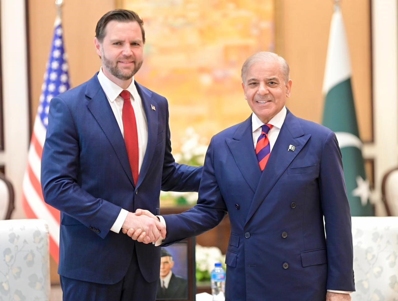 US Vice President JD Vance wearing a blue suit, white shirt, red tie, shaking hands with Pakistan's Prime Minister in a similar outfit.