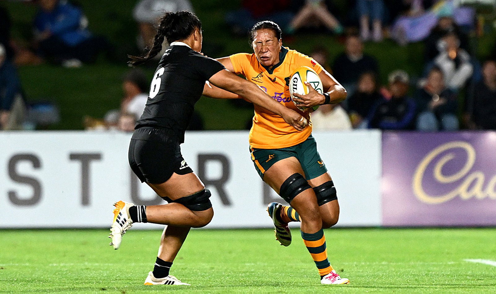 A Wallaroos player takes on Black Ferns defence.