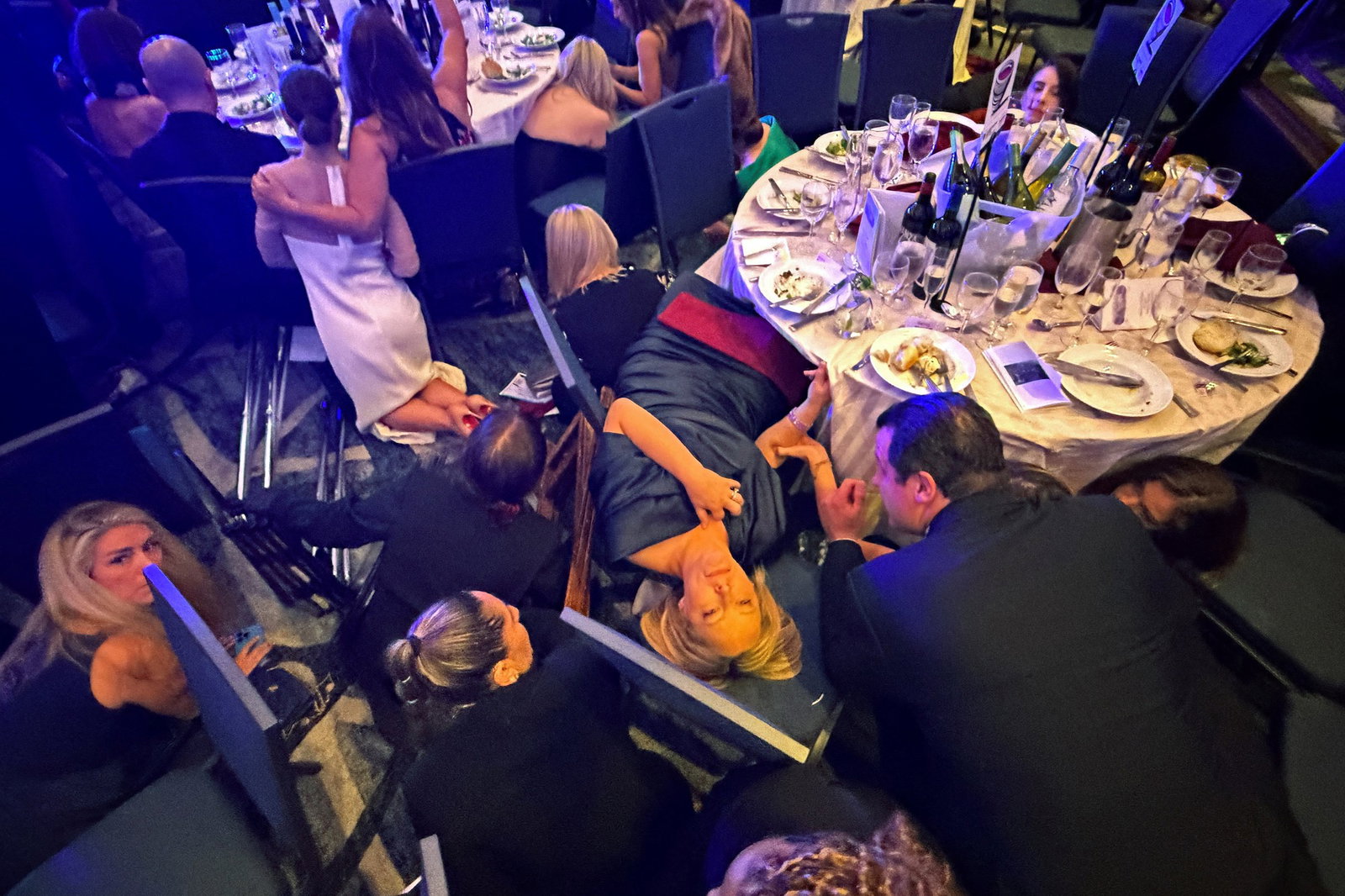 Guests hiding and lying down under tables.