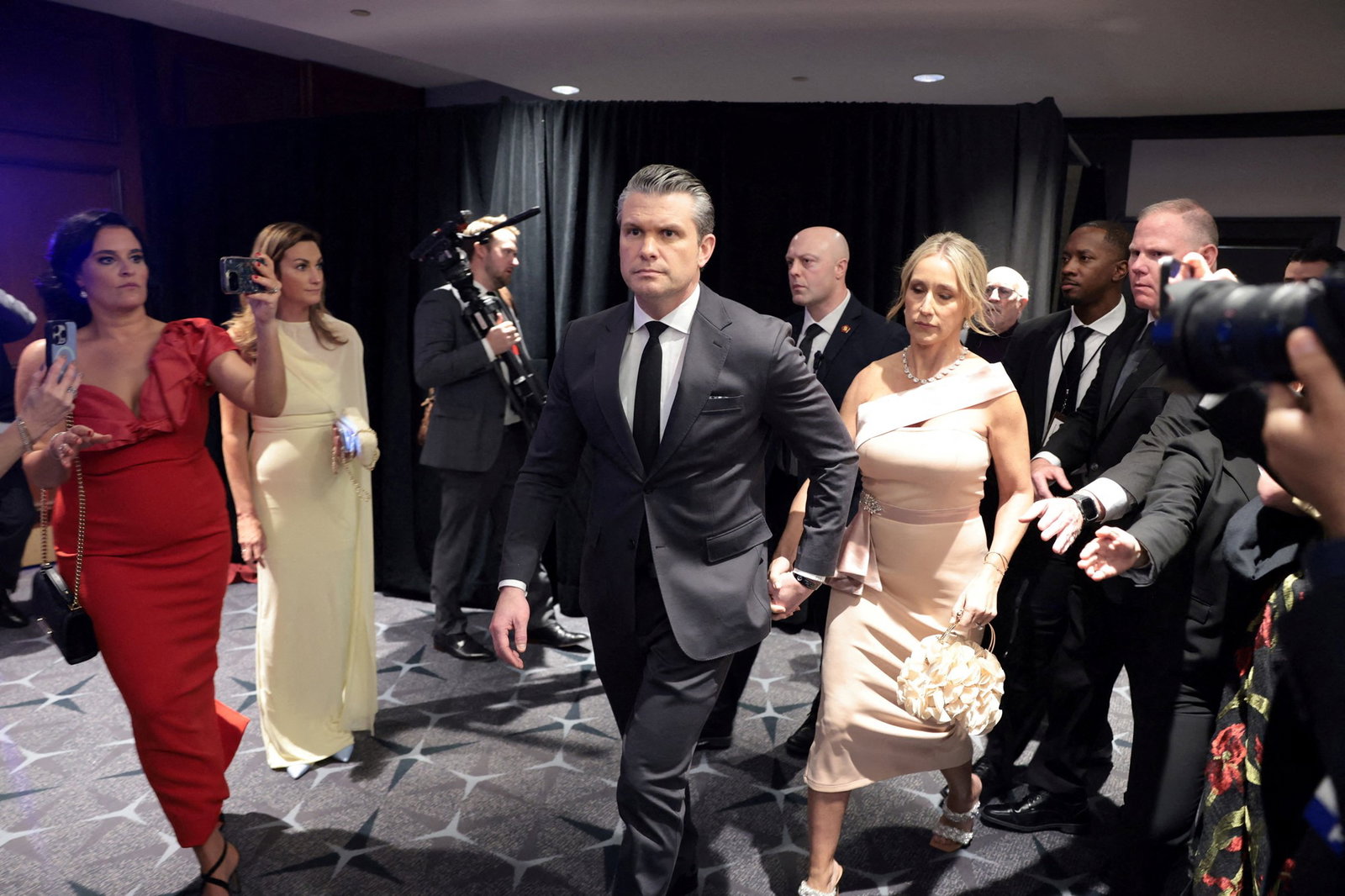 Pete Hegseth and his wife leaving the ballroom.