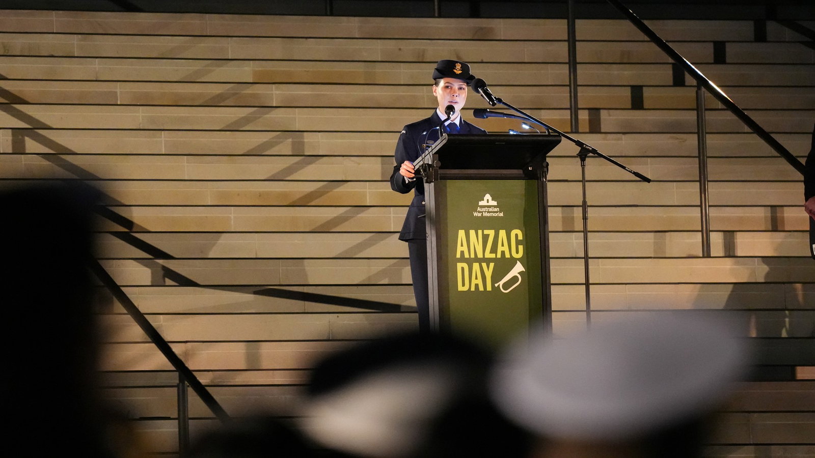 a young woman stands behind a lectern to deliver an address at a dawn service