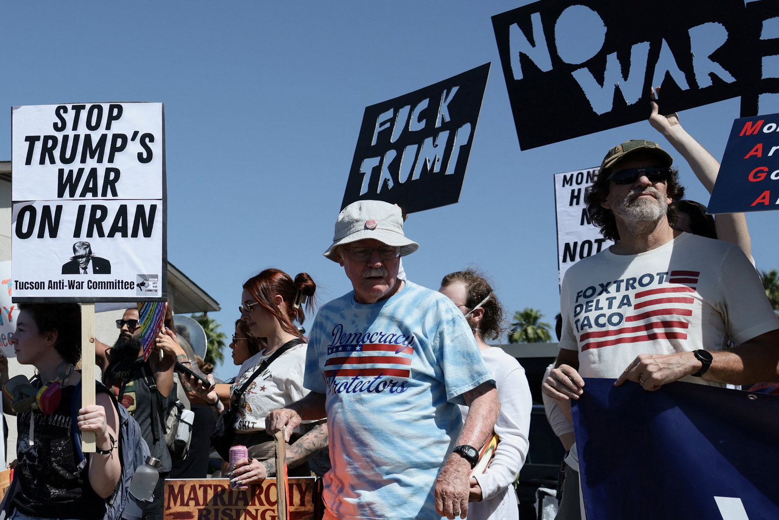 Protesters hold anti-Donald Trump signs.