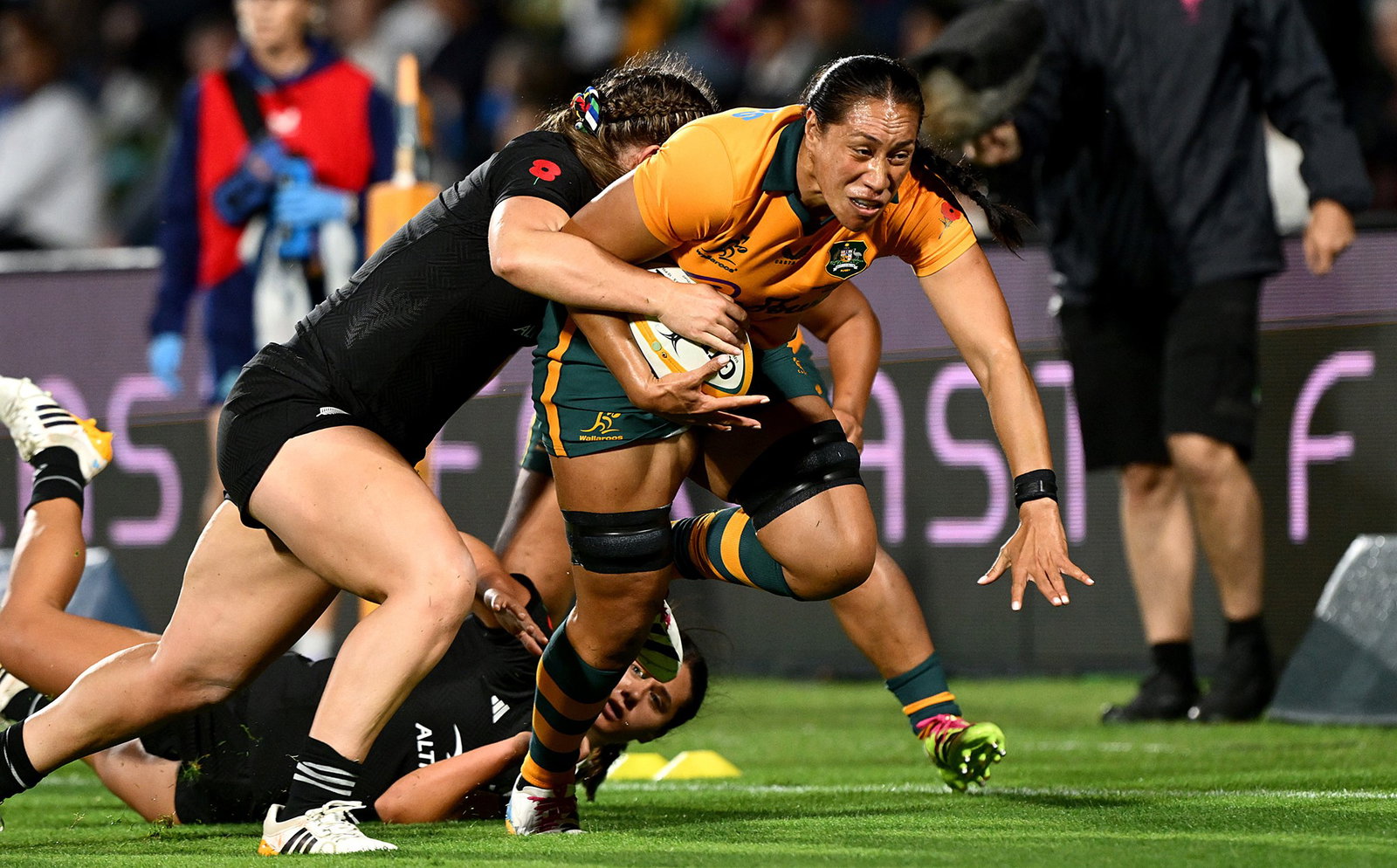 A Wallaroos player with the ball against Black Ferns.