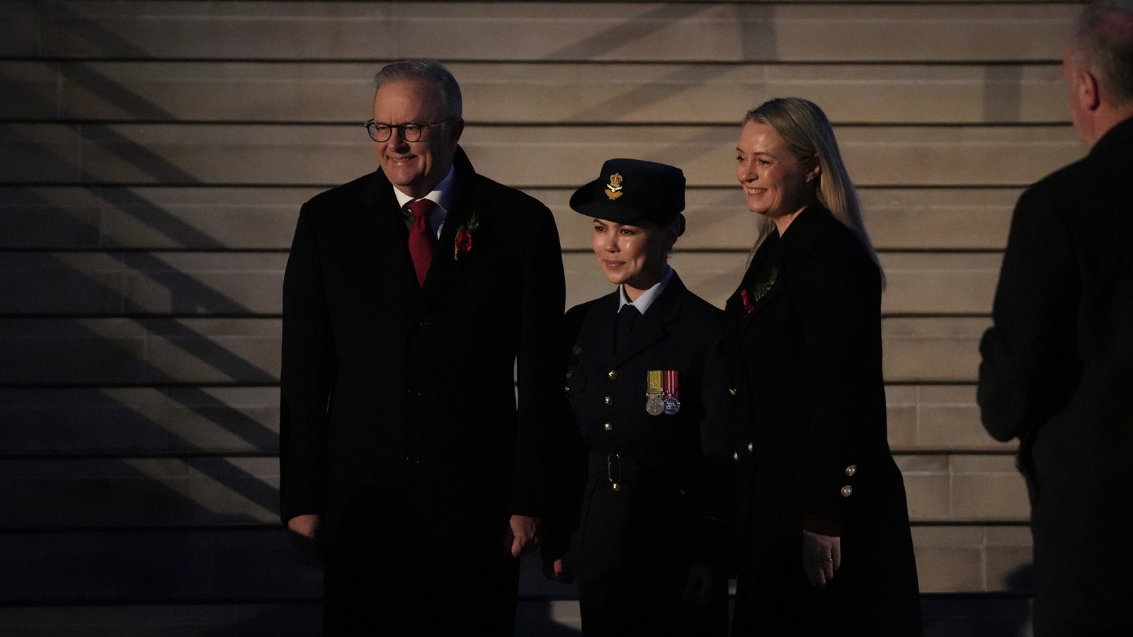 Anthony albanese, his wife and young navy soldier stand at the foot of some steps