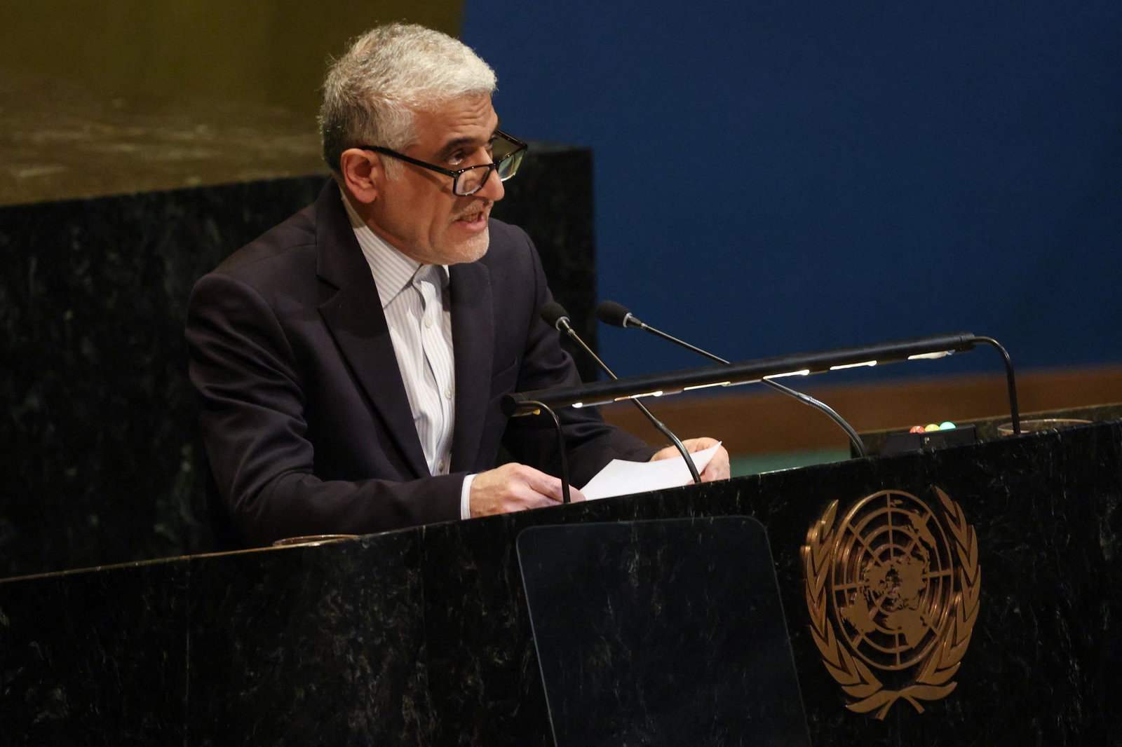 A man speaks into a microphone on a podium