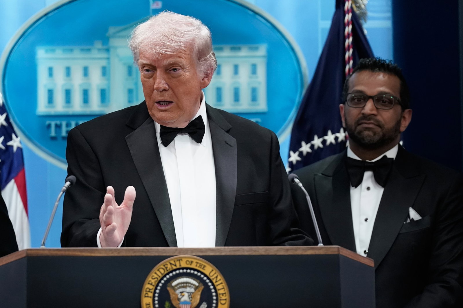 Trump speaking at the White House with Patel next to him.