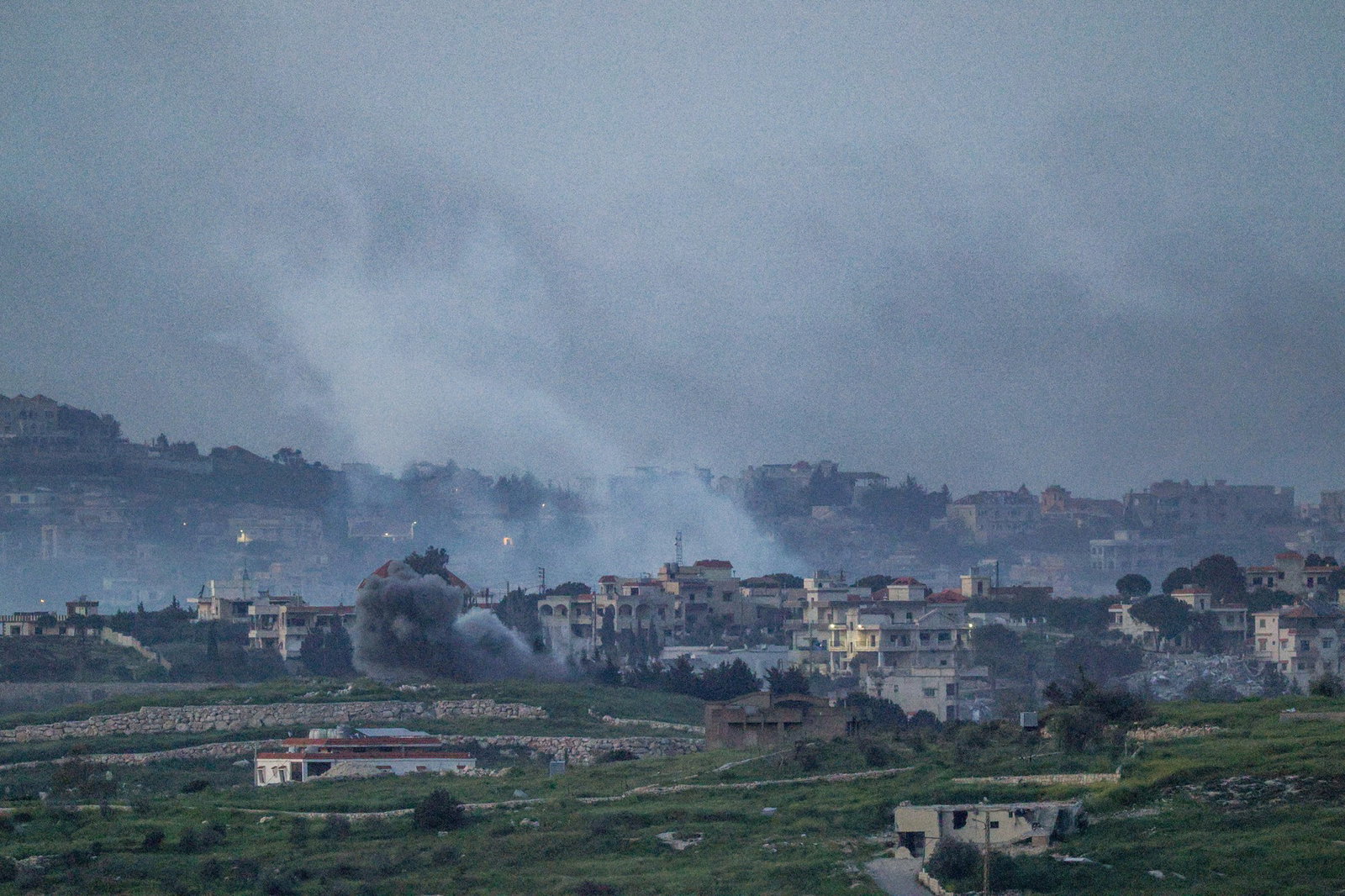 Smoke rises above a small village.