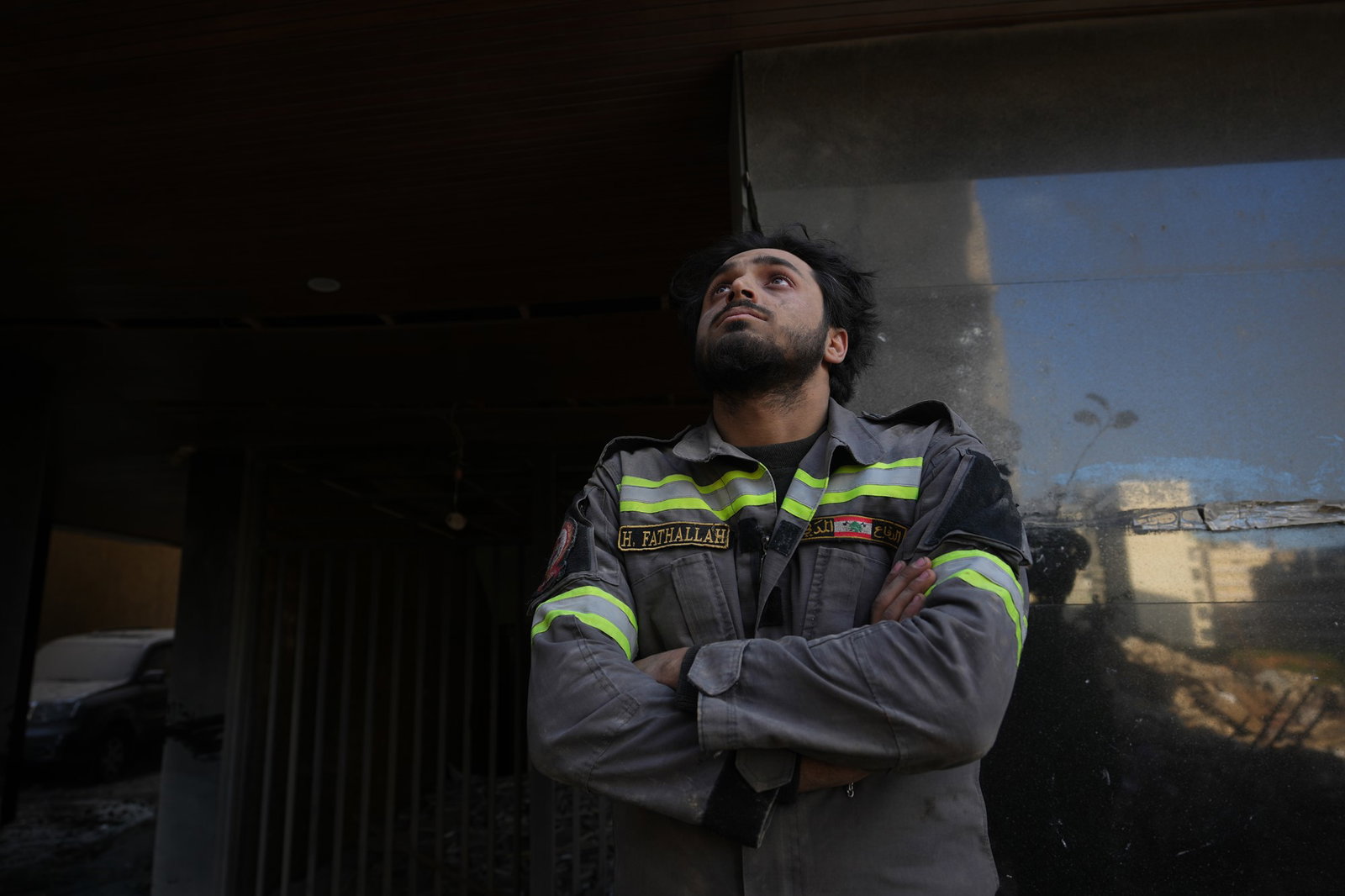 A Lebanese civil defense worker looks upward near the site of a building destroyed in an Israeli airstrike