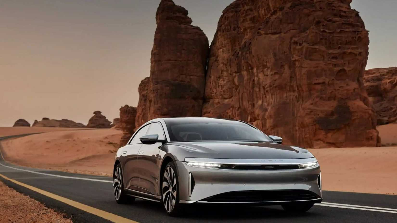 Gray Lucid Air Grand Touring driving on road through desert.