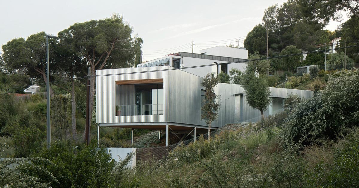 metallic house 144º rises on steel stilts above barcelona hillside