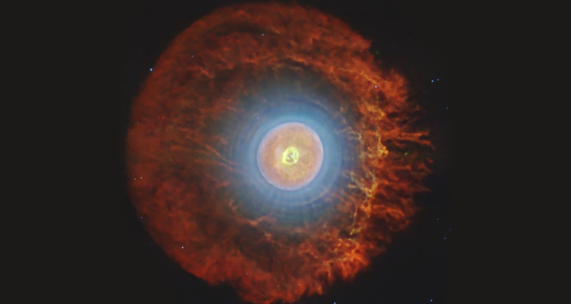 a cloud of blue, white with a ring of red light around it on a black background