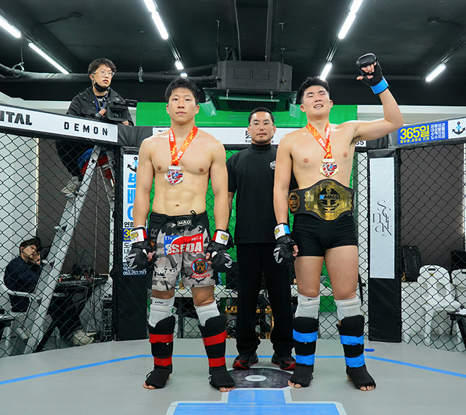 GOAT FC Jeon Min-gu is taking a photo to commemorate becoming the KMMA middleweight champion of the mixed martial arts group in April 2026. On the left is Seo Hyun-wook, who was a title match opponent. Photo = Representative Popeye's KMMA fighter agency is provided