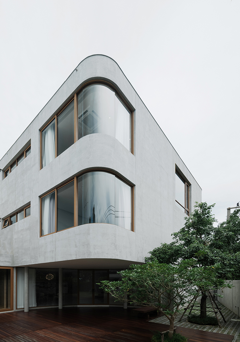 curved concrete volumes interlock through glass hinge to extend oom house in bangkok - 1