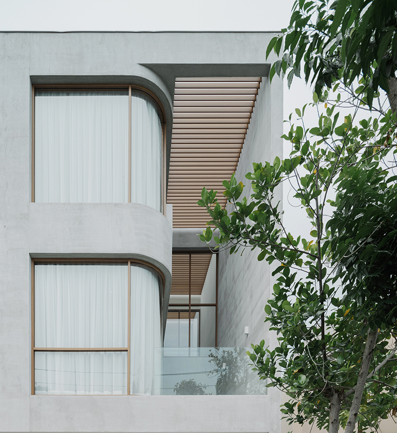 curved concrete volumes interlock through glass hinge to extend oom house in bangkok - 2
