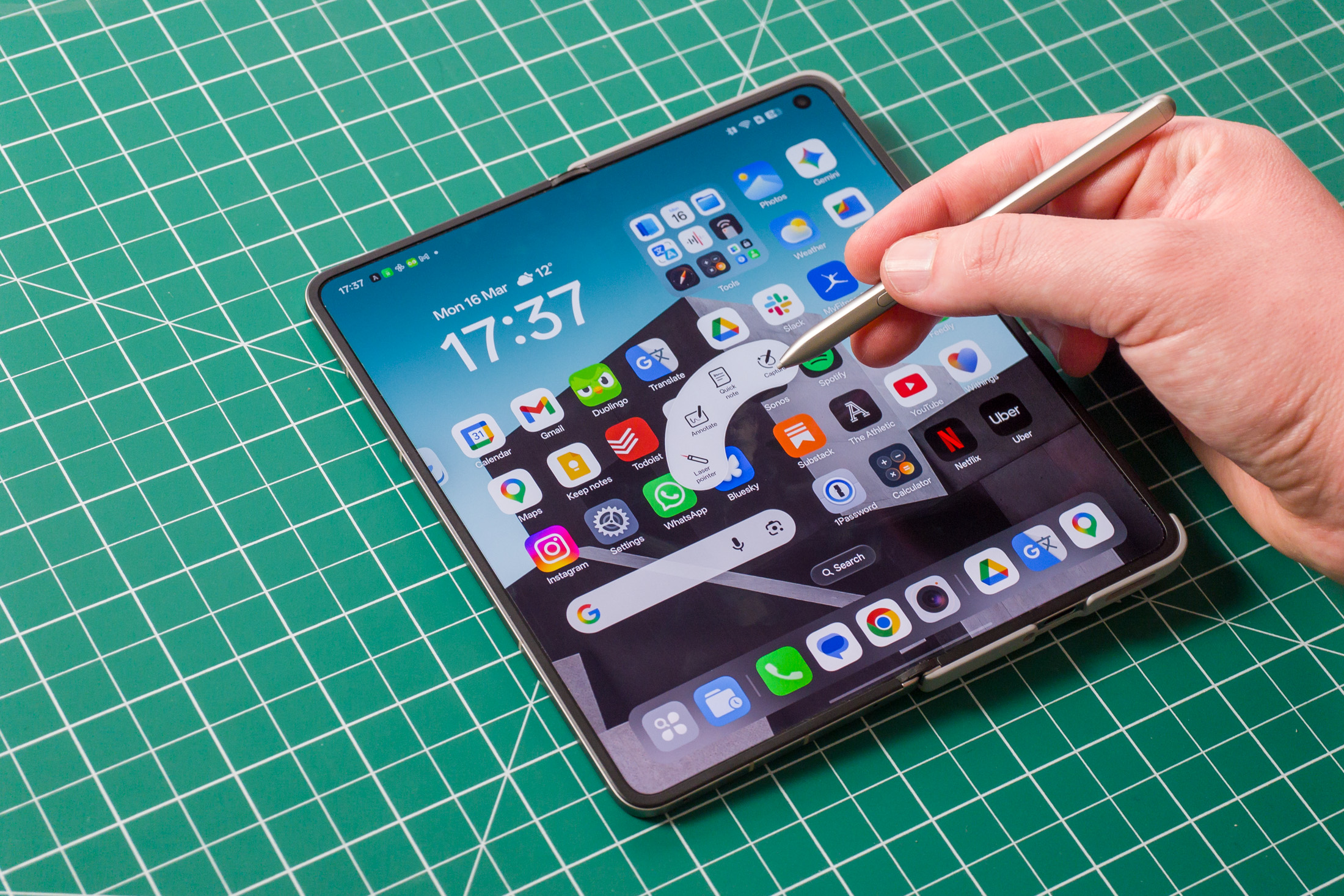 Photo of Oppo Find N6 on a green work mat from above, showing the AI Pen stylus controls