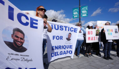 FILE - People display signs with with a likeness of Massachusetts State Police recruit Enrique Delgado-Garcia, who died following a State Police Academy training exercise, at a protest outside the State Police Academy graduation ceremony, Oct. 9, 2024, at the DCU Center, in Worcester, Mass. (AP Photo/Steven Senne, File)