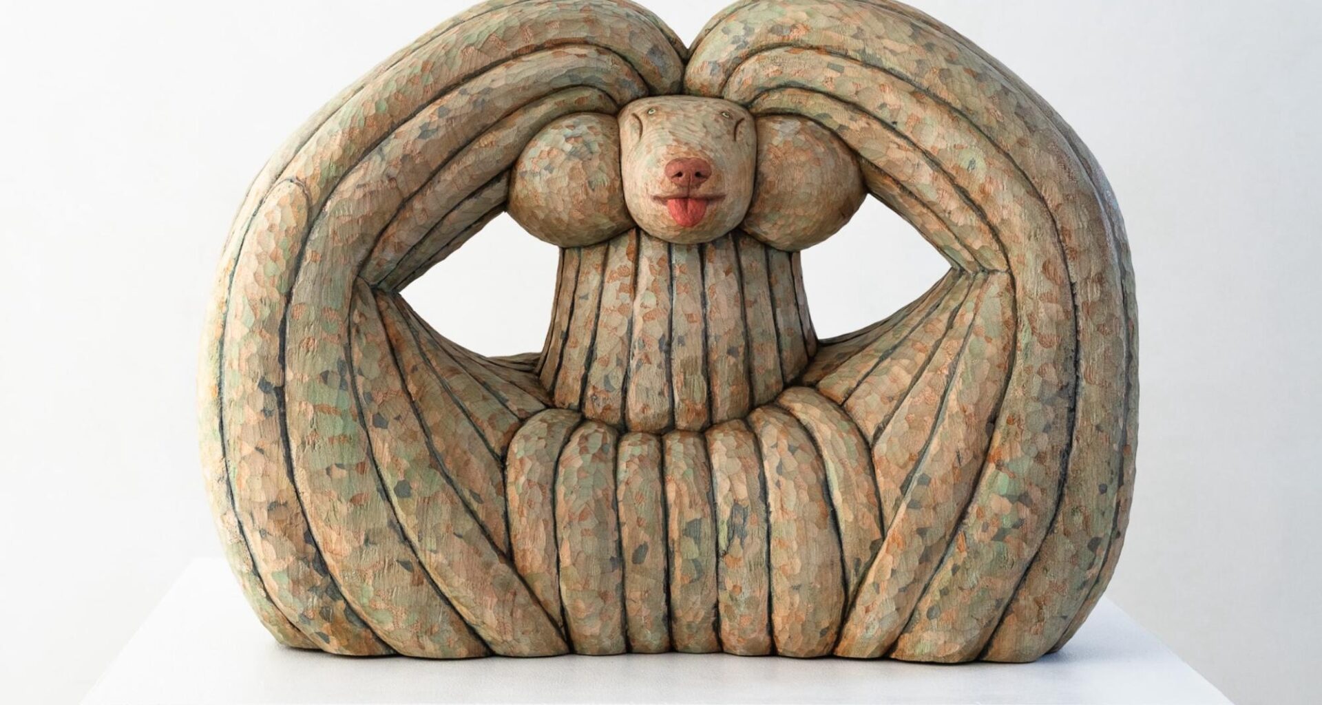 a wood-carved sculpture of a dog by Misato Sano