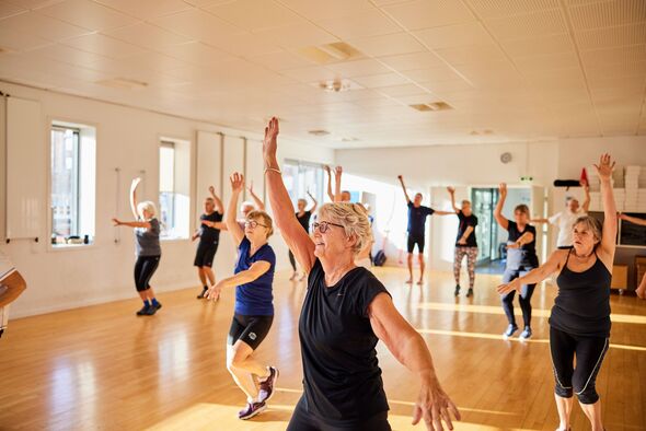 Smiling seniors taking an exercise class at the gym