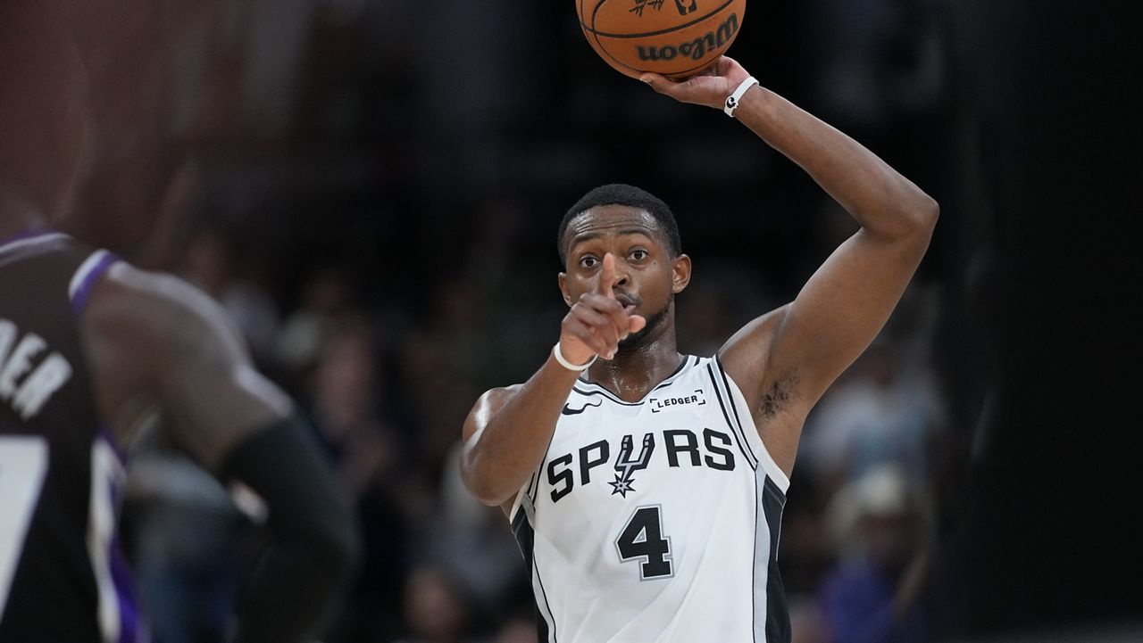 San Antonio Spurs guard De'Aaron Fox (4) signals as during the second half of an NBA basketball game against the Sacramento Kings in San Antonio, Sunday, Nov. 16, 2025. (AP Photo/Eric Gay)