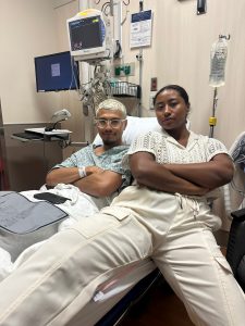 a man in a hospital bed and a woman sitting next to him on the bed
