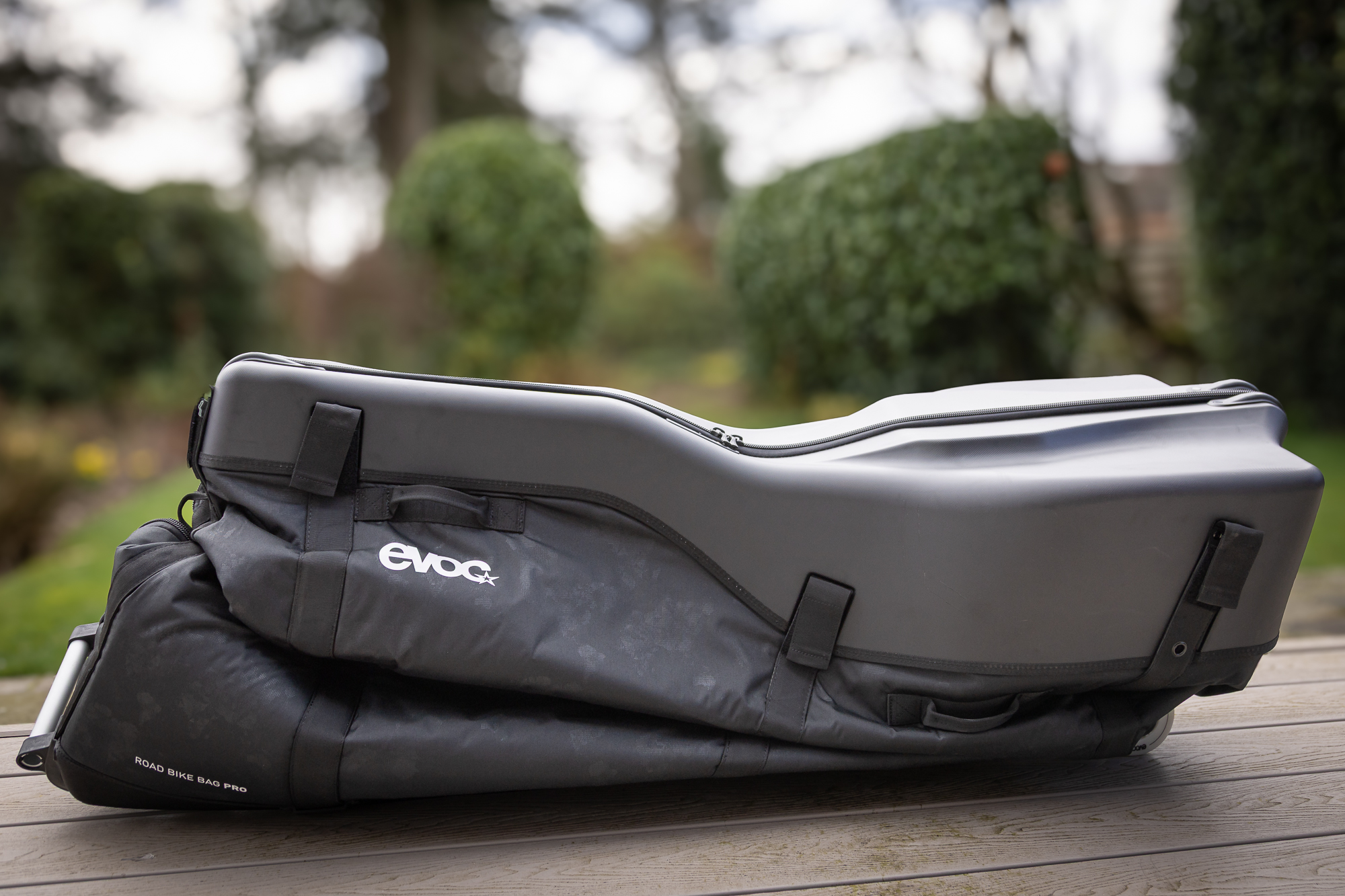 A squashed-down black bike bag in a garden