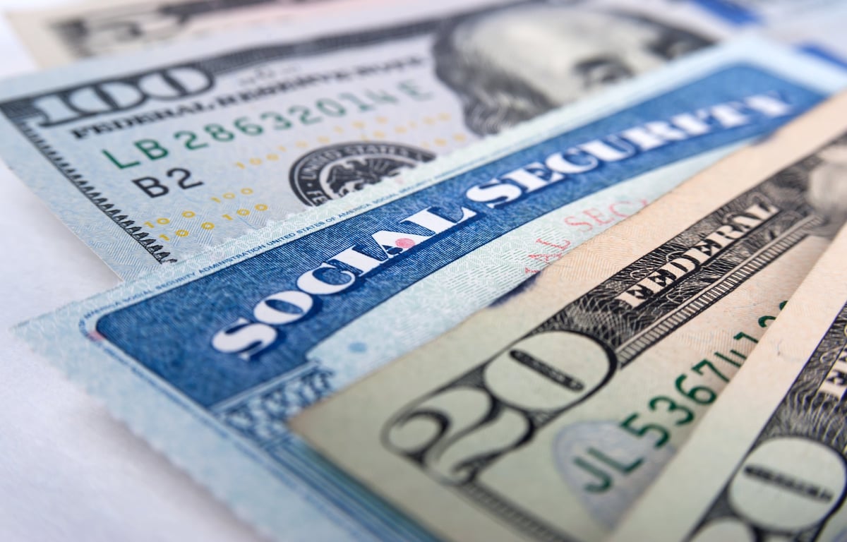 A Social Security card inserted between U.S. currency notes.