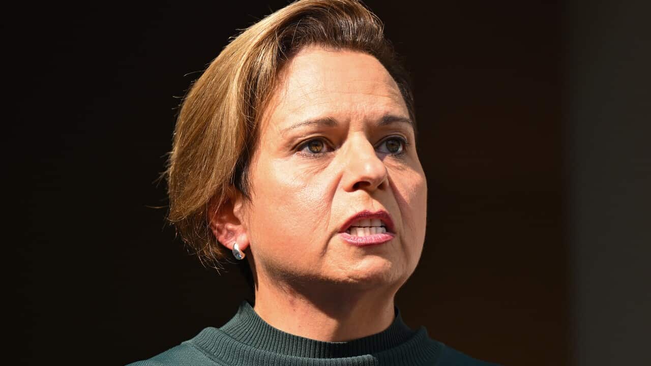 A close up shot of a woman with brown hair and a dark green jumper