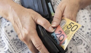 Hands holding a wallet with cash in it.