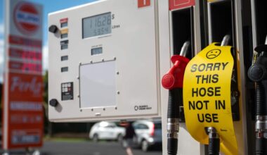 A sign saying 'sorry this hose not in use' on a petrol bowser at a service station