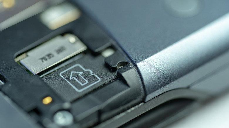 An old cell phone with the back removed exposing the microSD slot