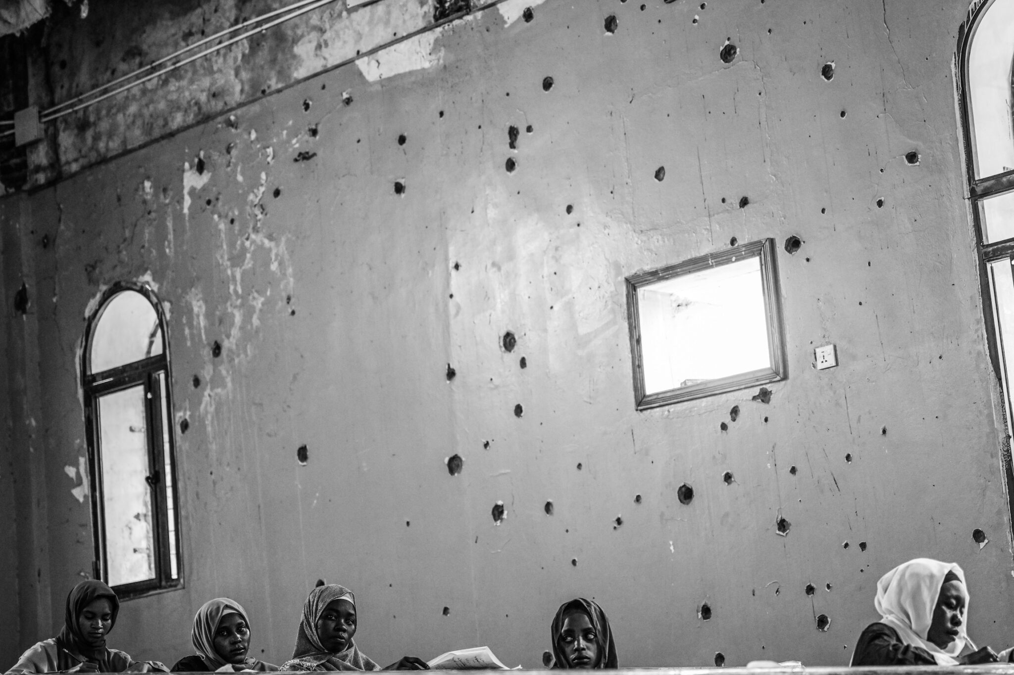 Abdulmonam Eassa, “Sudan’s War: A Nation Trapped,” for Le Monde. Students take exams at the war-damaged Omdurman Islamic University. Schools and universities have been attacked and mostly closed since fighting began. Omdurman, Sudan, December 4, 2025.