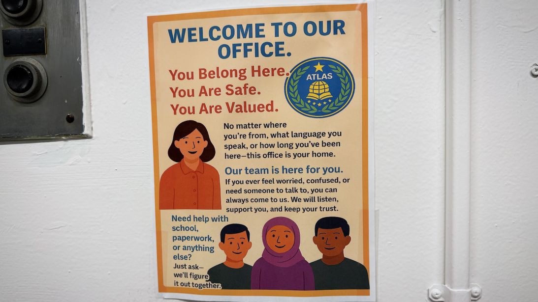 Signage around ATLAS High School welcomes migrant students.