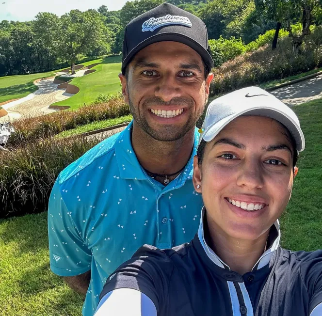 Aaron Rai and his wife Gaurika Bishnoi taking a selfie on a golf course.