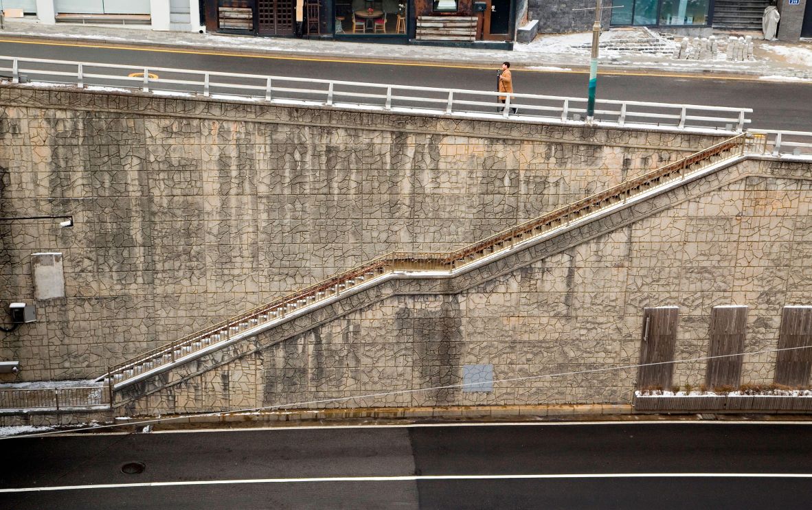 <strong>Stairs near Jahamun Tunnel: </strong>Featured in one of the most iconic sequences from 2019’s “Parasite,” these steep steps are where Ki‑taek’s family rushes downhill in the pouring rain after fleeing the Park residence late at night. Director Bong Joon Ho uses the long, vertical descent to visually express the film’s central theme of class division, with the Jahamun Tunnel below marking the transition back to the family’s semi-basement reality.