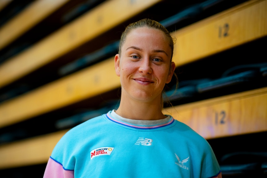 Woman in blue shirt smiles.