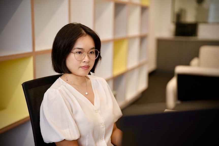A young woman seated in an office