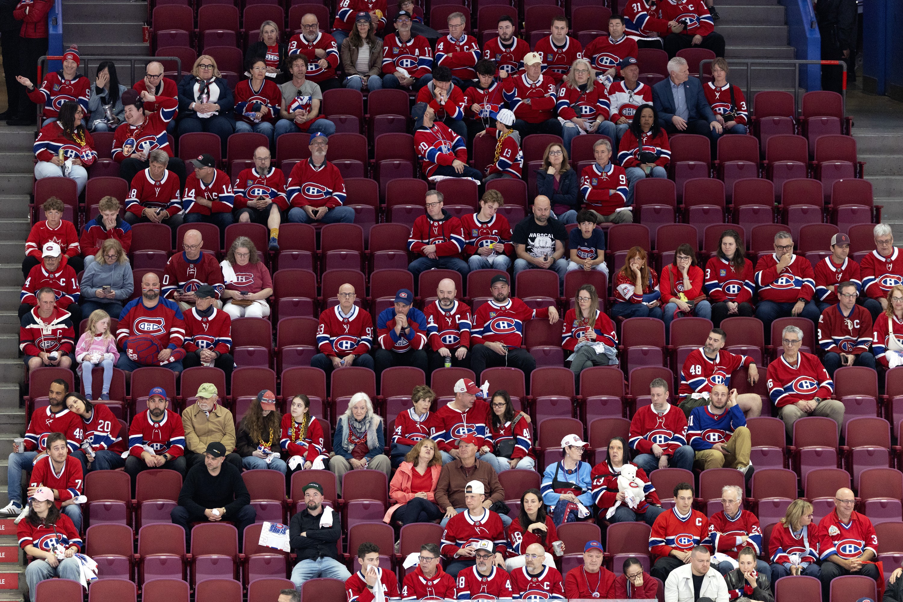 Hockey arena stands are half-empty in the third period as the home team was losing badly.  