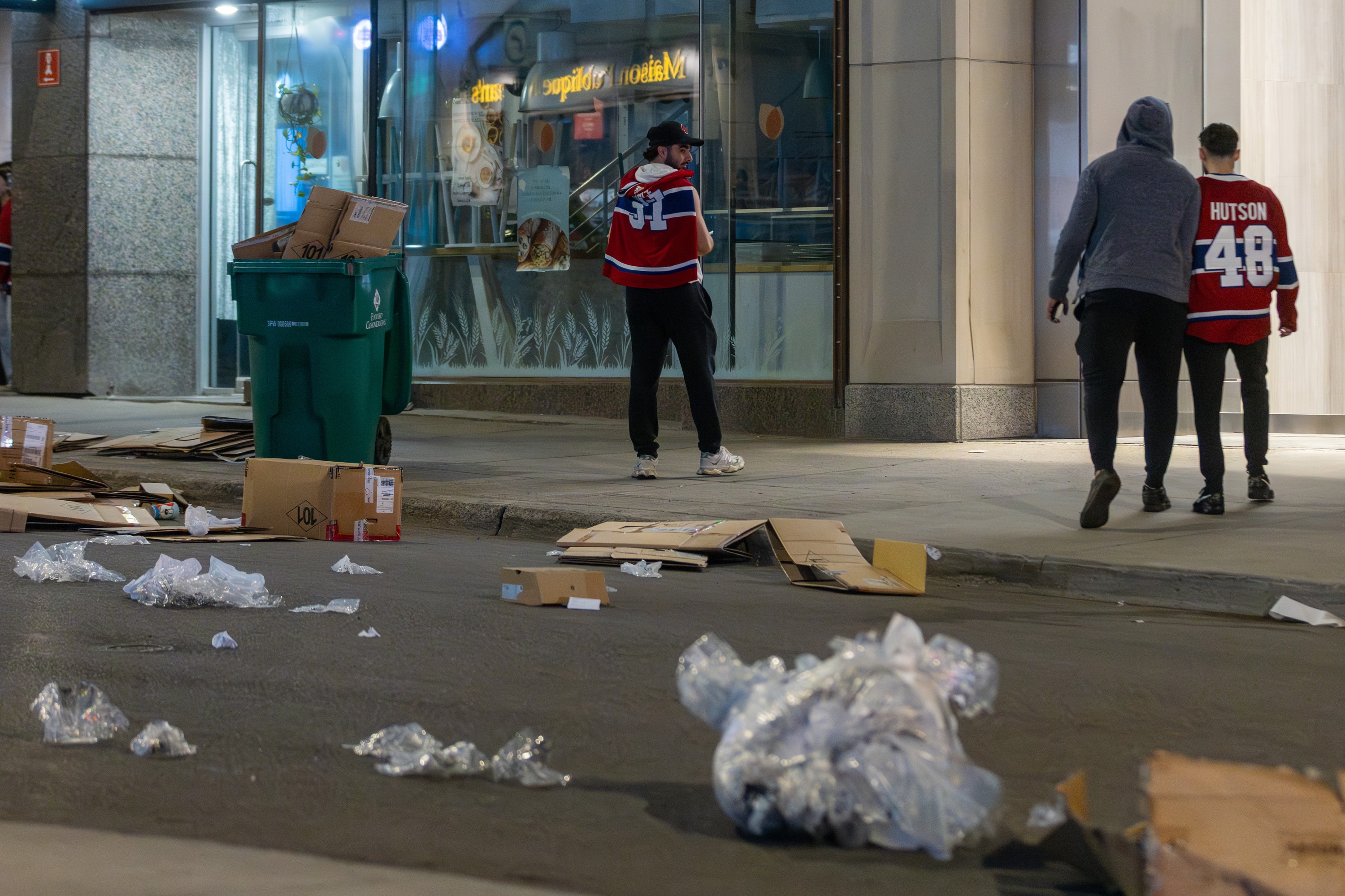 Some scattered Canadiens fans around a street littered with trash