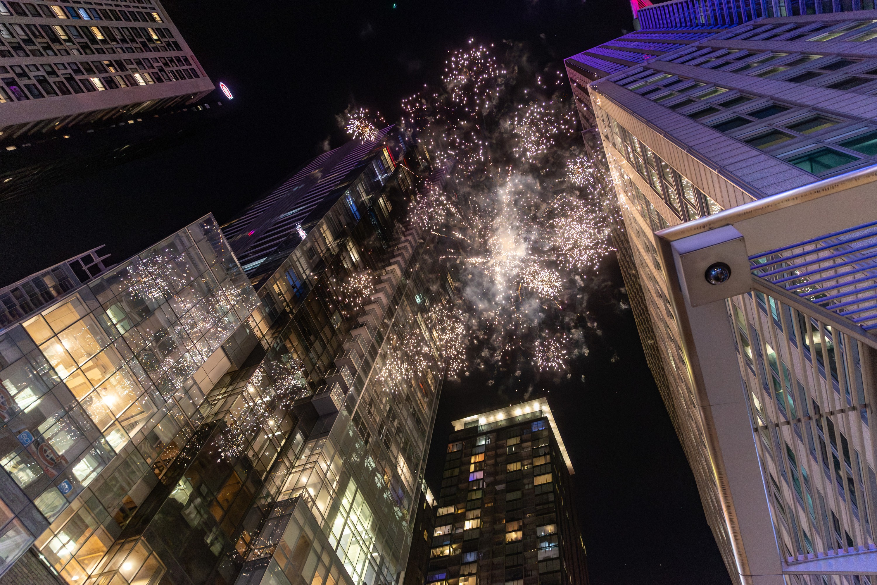 Fireworks go off between downtown skyscrapers