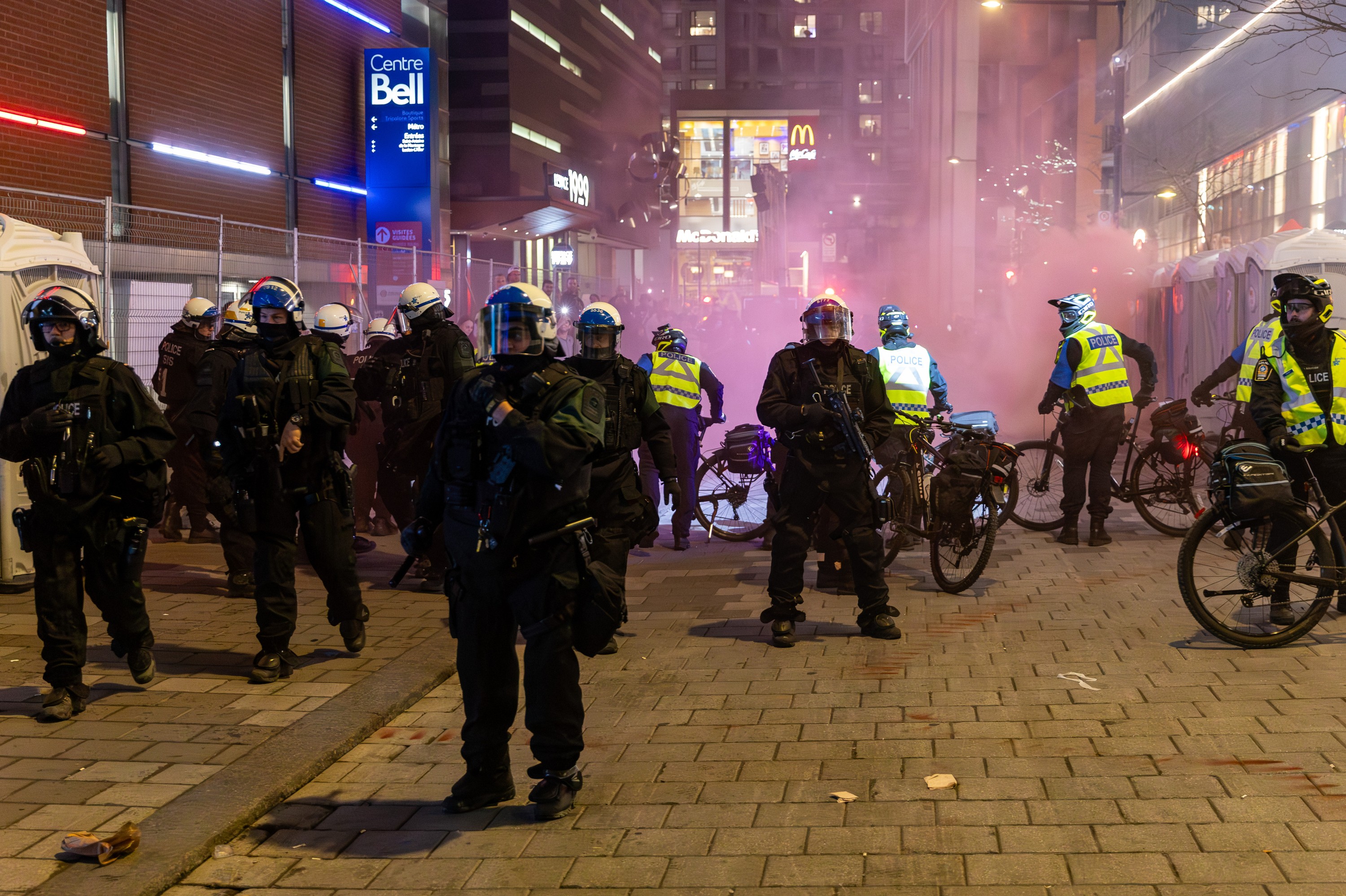 Police in riot gear gather as smoke fills the air