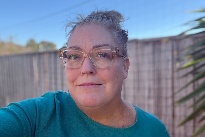 Woman staring at camera with fence in background