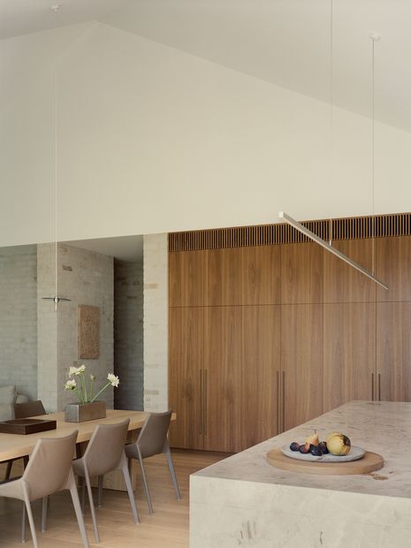 Open-plan living areas unfold beneath a raked ceiling that draws light deep into the interior. Artwork: Ro Noonan.
