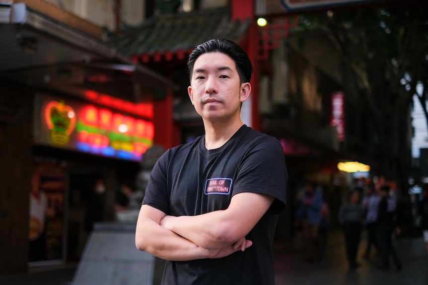 a young man with arms crossed looking at the camera