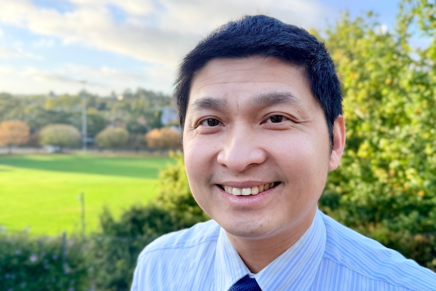 Scientist pictured in front of a university sporting oval.