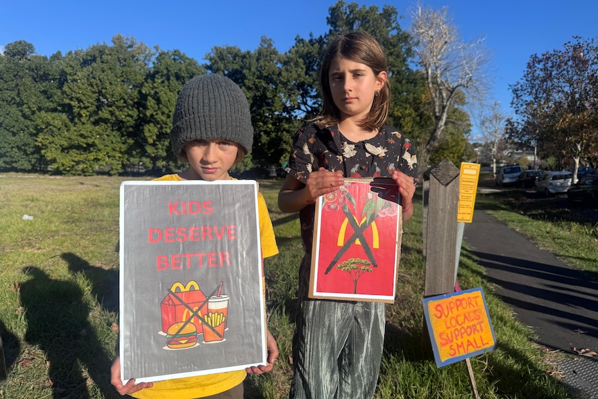 Two children holding protest signs.