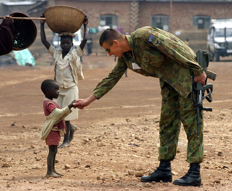 1995 Walkley award winning photograph by Tony Ashby of Corporal Trevor Brown shaking the hand of a child in Kibeho, a camp near the southern town of Butare in Rwanda. Picture: Tony Ashby