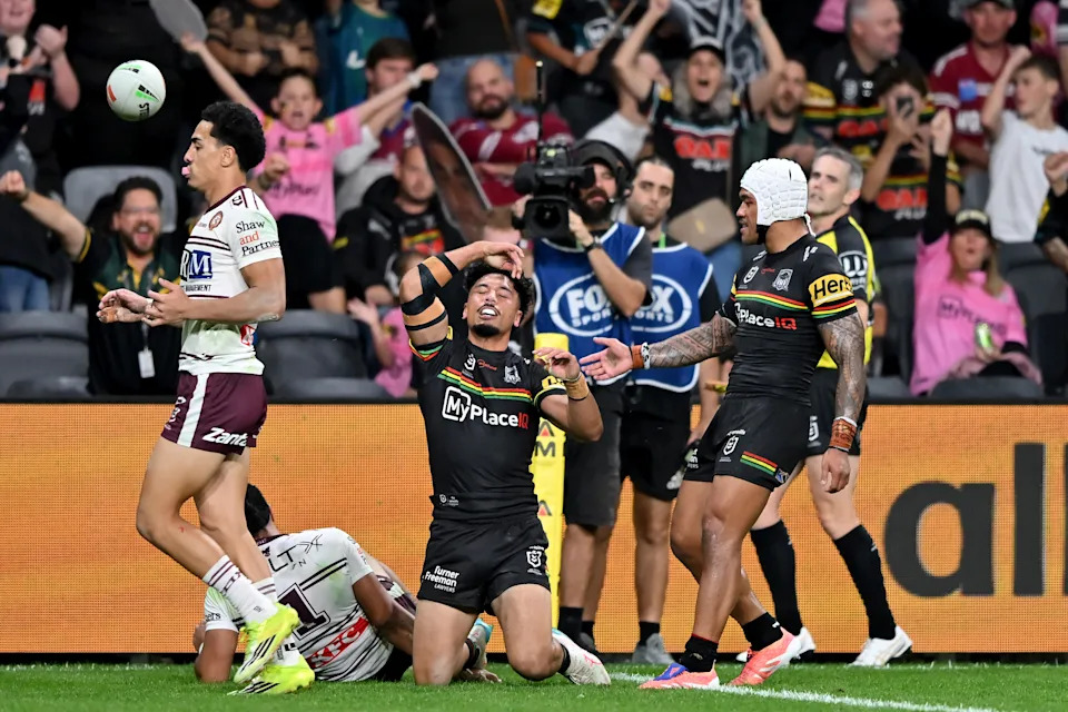 Pictured centre, Izack Tago celebrates the game-clinching try for the Panthers against Manly. 